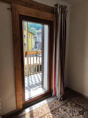 a room with a window with a view of a balcony at Casa di Volce - 1801 Stone House in Tolmin