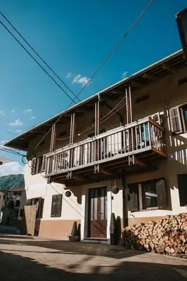 a building with a balcony on the side of it at Casa di Volce - 1801 Stone House in Tolmin