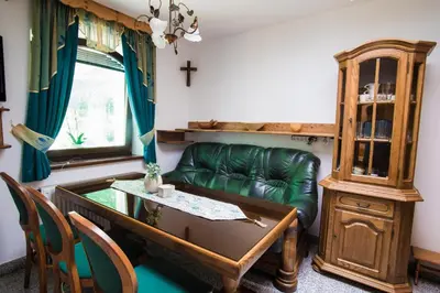 a living room with a green couch and a table at Estate Žagmeštri in Ljubno