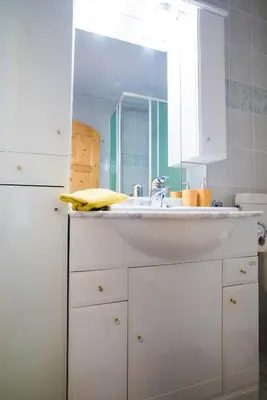 a white kitchen with a sink and a mirror at Estate Žagmeštri in Ljubno