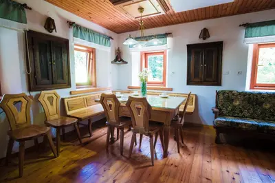 a dining room with a table and chairs and a couch at Estate Žagmeštri in Ljubno