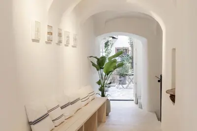 a hallway with white walls and a bench with a plant at April1550 Boutique Hotel in Ljubljana