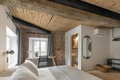 a bedroom with a large bed and a desk at April1550 Boutique Hotel in Ljubljana