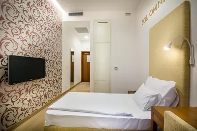 a hotel room with a bed and a tv on a wall at Rimske Terme Resort - Hotel Sofijin dvor in Rimske Toplice
