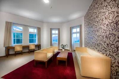 a waiting room with a couch and chairs and windows at Rimske Terme Resort - Hotel Sofijin dvor in Rimske Toplice