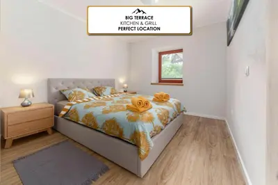 a bedroom with a bed with towels on it at Apartments Ribnica in Bohinj