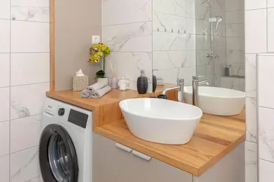 a bathroom with a sink and a washing machine at Apartments Ribnica in Bohinj