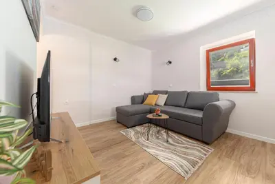 a living room with a couch and a tv at Apartments Ribnica in Bohinj