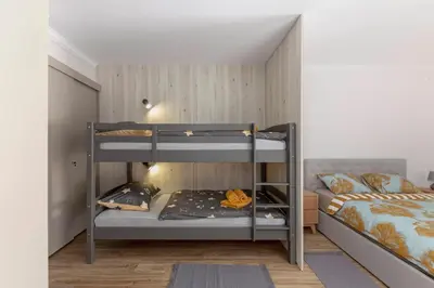 two bunk beds in a room with a bed at Apartments Ribnica in Bohinj
