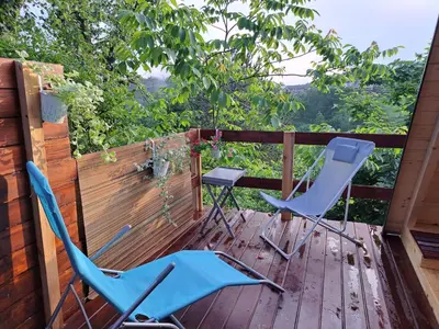 two chairs and a table on a wooden deck at Ozy's place in Kamnik