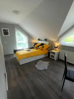a bedroom with a yellow bed and a table and window at Apartment Jovan in Bled