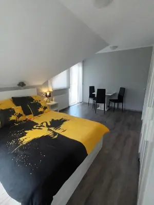 a bedroom with a bed and a table with chairs at Apartment Jovan in Bled