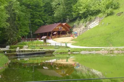 a gazebo next to a lake with green water at VILA HELENA in Velenje