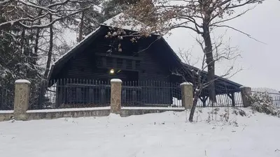 a log cabin with a fence in the snow at VILA HELENA in Velenje