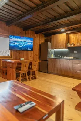 a living room with a table and a kitchen at VILA HELENA in Velenje