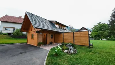 a house with a gambrel roof and a driveway at A Nest Under the Karawanks in Žirovnica