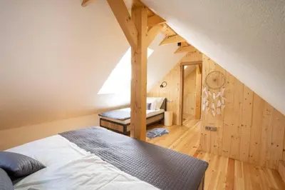 a bedroom with a bed in a room with wooden walls at A Nest Under the Karawanks in Žirovnica