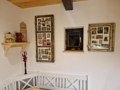 a room with pictures and mirrors on a wall at Vineyard cottage Vinska grajska kašča in Mirna