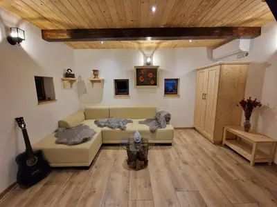 a living room with a couch and a guitar at Vineyard cottage Vinska grajska kašča in Mirna