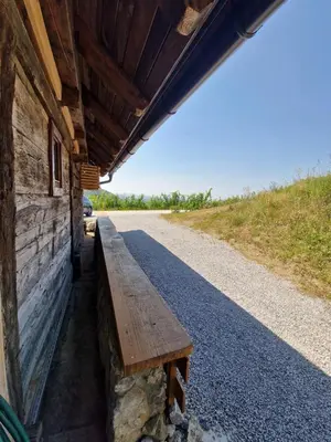 a wooden bench sitting on the side of a building at Vineyard cottage Vinska grajska kašča in Mirna