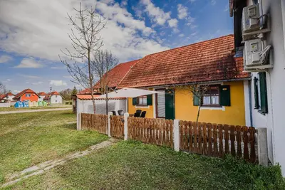 a yellow house with a wooden fence next to it at Spa House Alenka Terme Čatež in Čatež ob Savi