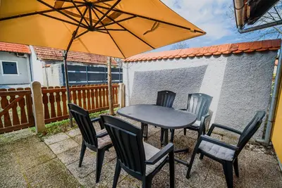 a table and chairs with an umbrella on a patio at Spa House Alenka Terme Čatež in Čatež ob Savi