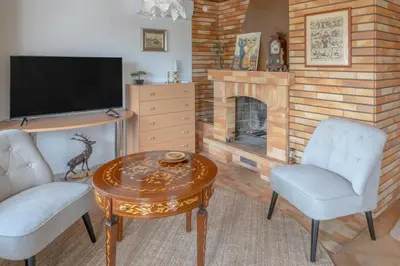 a living room with a fireplace and a table and chairs at Mia Dream in Bled