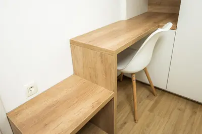 a wooden desk and a white chair in a room at Apartments Gros in Radeče