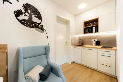 a living room with a blue chair and a lamp at Apartments Gros in Radeče