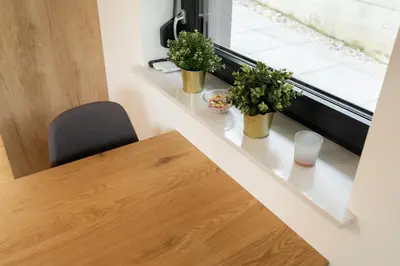 a dining room table with two potted plants and a window at Apartments Gros in Radeče