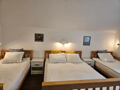 two beds in a room with white sheets and yellow pillows at Hadam's Apartments in Bled