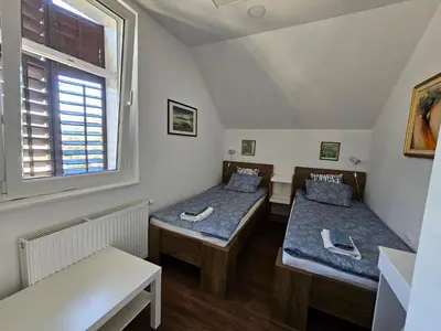 a room with two beds and a window at Hadam's Apartments in Bled