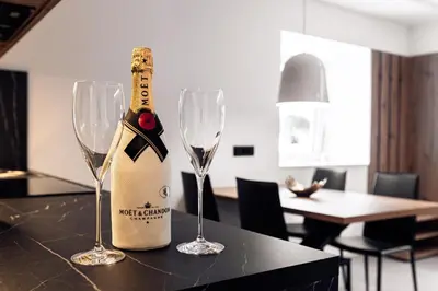 a bottle of champagne and two wine glasses on a table at APARTMENTS Goldi Superior in Stahovica