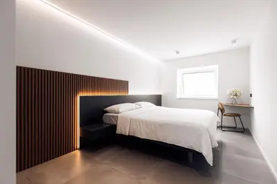 a bedroom with a large bed with a wooden headboard at APARTMENTS Goldi Superior in Stahovica