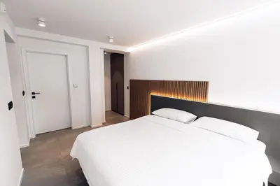 a white bedroom with a large white bed in it at APARTMENTS Goldi Superior in Stahovica