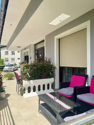 a patio with pink and black chairs and a table at Ana Rooms Bled in Bled