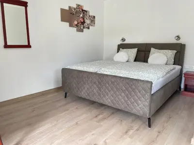 a bed in a bedroom with a wooden floor at Ana Rooms Bled in Bled