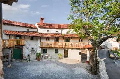 an exterior view of a large house with a deck at Karst Heritage Retreat in Štanjel