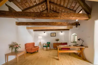a living room with a desk and a chair at Karst Heritage Retreat in Štanjel