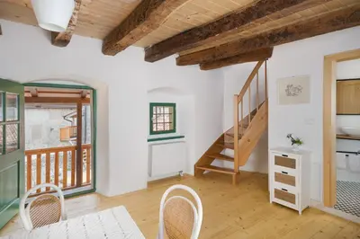 a room with a staircase and a table and chairs at Karst Heritage Retreat in Štanjel