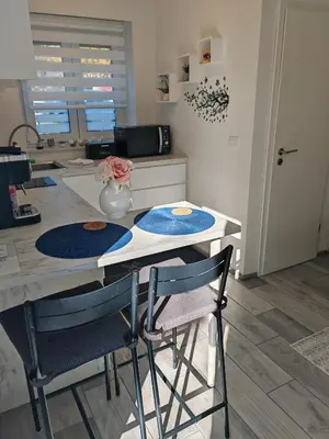 a kitchen with a counter with two chairs and a table at Blue apartment with FREE parking in Ljubljana