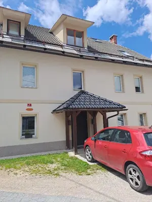 a red car parked in front of a house at Apartment Danica in Kranjska Gora