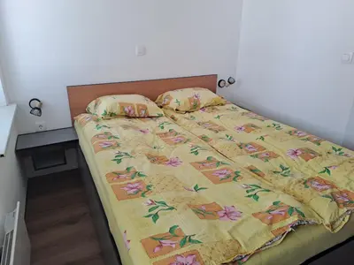 a bed with a yellow comforter and two pillows at Apartment Danica in Kranjska Gora