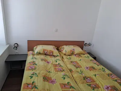 a bed with a yellow comforter and two pillows at Apartment Danica in Kranjska Gora