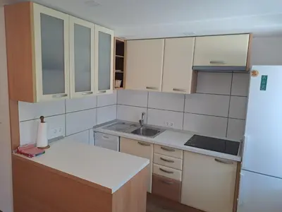 a kitchen with white cabinets and a sink and a refrigerator at Apartment Danica in Kranjska Gora
