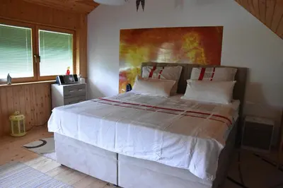 a bedroom with a large white bed with a painting on the wall at Apartment in Grabrovec - Koroska Unterkärnten 44968 in Metlika