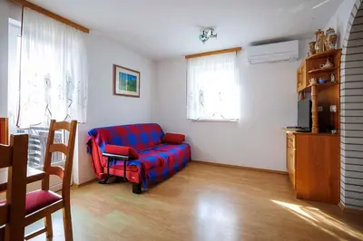 a living room with a blue couch and a chair at Holiday home in Adlesici - Dolenjska & Bela krajina Unter- & Weißkrain 44970 in Adlešiči