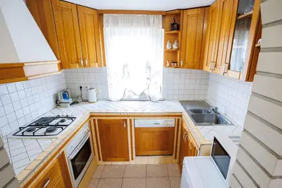 a small kitchen with wooden cabinets and a window at Holiday home in Adlesici - Dolenjska & Bela krajina Unter- & Weißkrain 44970 in Adlešiči