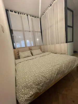 a bed in a room with a large window at Apartmaji Winter Garden Kranjska Gora in Kranjska Gora
