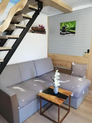 a living room with a blue couch and a wooden table at Cosy Retreat Čatež in Čatež ob Savi